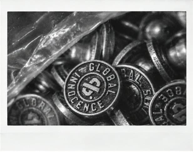 Metal buttons with the Global Innocence logo.